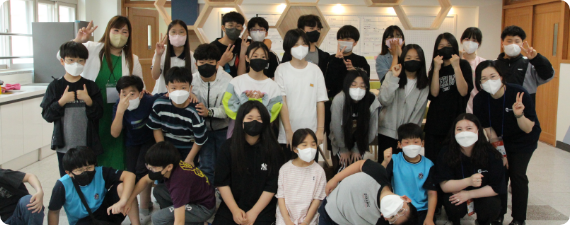 한 교육기관에서 강사와 아이들이 사진을 찍고 있다